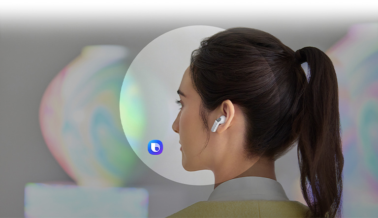 Знімок жінки ззаду, у вусі якої білий Galaxy Buds4 Pro. Поруч, текстова бульбашка з питанням до AI: «Що таке місячна кераміка?» Нижче, ще одна текстова бульбашка з відповіддю: «Місячна кераміка – підвид традиційної корейської порцеляни, що включає круглі корейські чаші з білої порцеляни, які вироблялися в епоху Чосон. Їхня плавна, опукла й майже сферична форма і молочно-біла глазур нагадують повний місяць». Під нею – перелік основних відомостей про місячну кераміку.