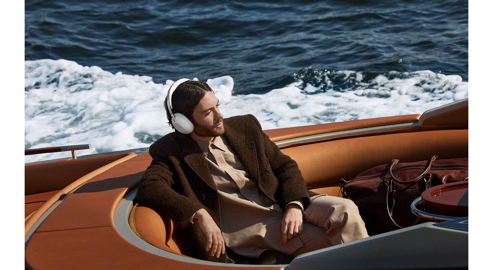 Мужчина в белых наушниках Sony 1000X THE COLLEXION в лодке на воде