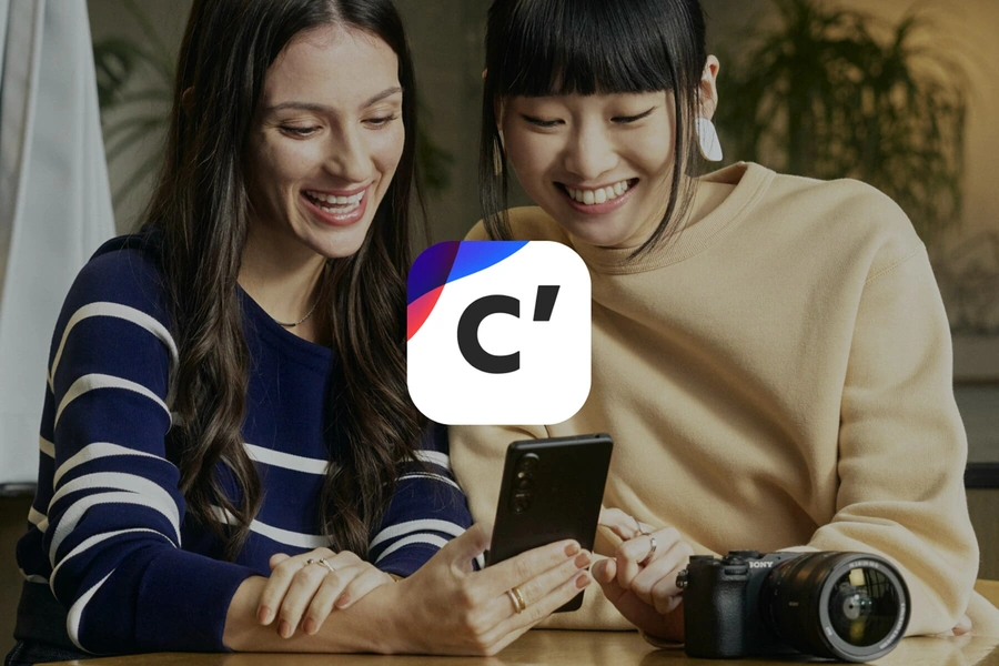 Изображение двух женщин, которые смотрят в смартфон; поверх размещён логотип сервиса Creators’ Cloud