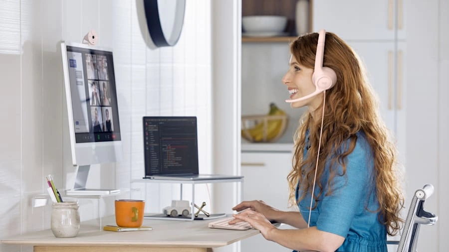 Женщина в гарнитуре Logitech H390 за компьютером