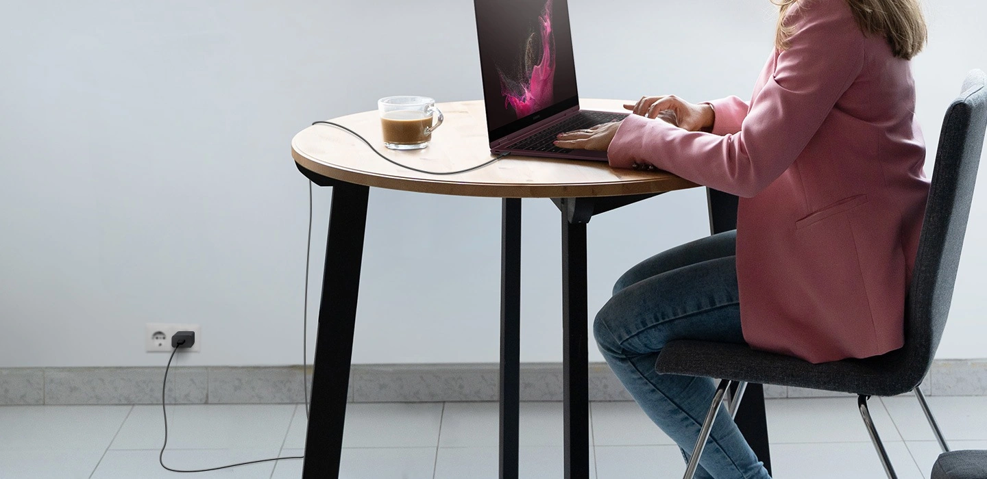 Человек за столом работает на ноутбуке Galaxy Book, подключённом кабелем USB Type-C