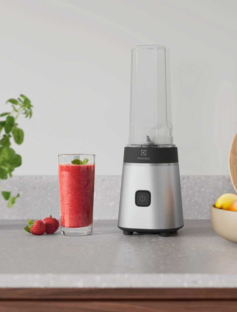Блендер Electrolux E3SB1-4ST на кухонній стільниці поруч зі склянкою ягідного смузі