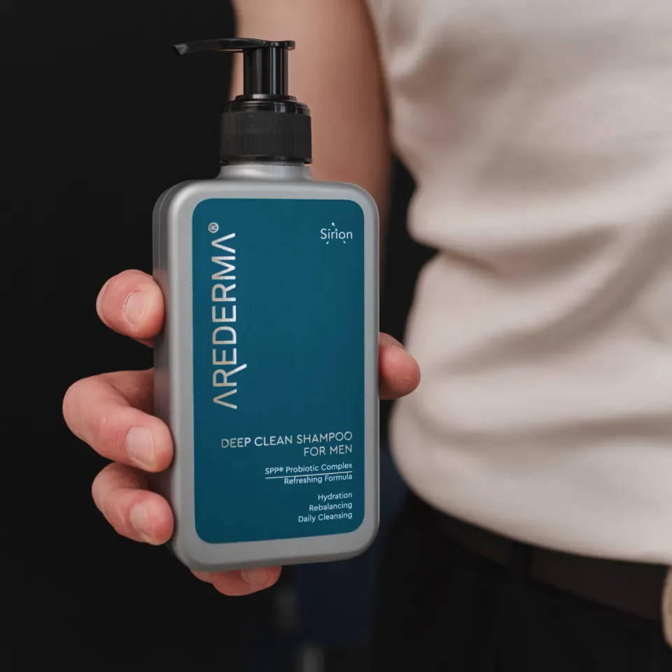 Флакон чоловічого шампуню глибокого очищення AREDERMA Deep Clean у руці