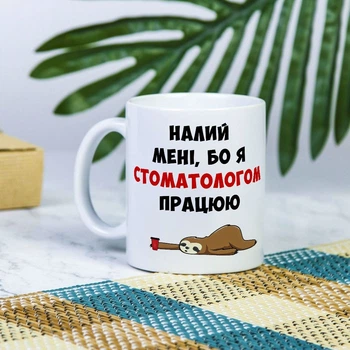 Біла чашка на подарунок з написом "Налий мені, бо я стоматологом працюю" 330 мл