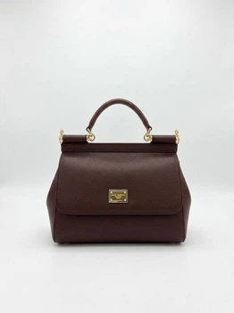 Жіноча сумка Dolce & Gabbana Miss Sicily Bag 19*12*6,5 см глибокого бордового кольору (марсала/бордо) з тисненої шкіри Dauphine зі золотистою фурнітурою та двоколірною фірмовою пластиною Dolce & Gabbana.