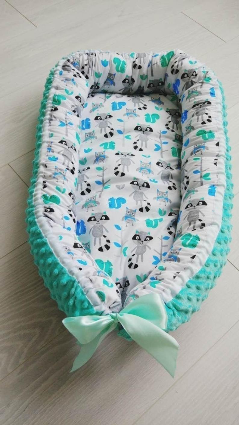 

Кокон для ребенка MammyDo Racoons мятного цвета с енотами