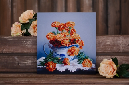 

Вышитая бисером картина на подрамнике Картины Бисером Вышитая бисером картина "Бархатцы на столе" ()